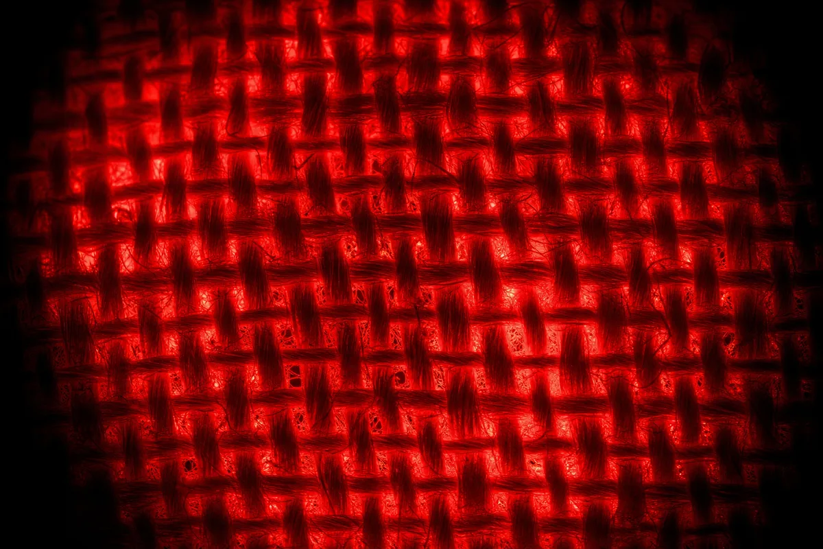 Lumière rouge diffuse traversant un drap de coton blanc dans une pièce sombre